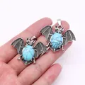 Detailed close-up of bat-shaped pendants with blue turquoise stone and silver alloy finish - Blue Turquoise