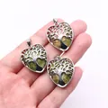 Close-up of three heart-shaped unakite pendants featuring silver tree of life metalwork - Unakite