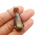 Faceted smoky crystal perfume bottle pendant necklace with silver chain shown in hand - 25x38mm / Smoky Quartz