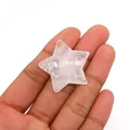 Sternförmige Perle aus natürlichem Rosenquarz zur Größenansicht in der Hand - 30mm (Dicke 8mm), 9g / Weiß Kristall