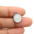 Pendente rotondo d'argento con pietra bianca traslucida tenuto per mostrare la misura - Cristallo di rocca / 12x15mm