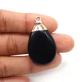 Close-up of black teardrop natural stone pendant with silver plated metal clasp - Black Agate