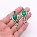 Green crystal wing and key pendants held in hand for size visualization in silver finish - Malay Jade