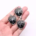 Black heart stone pendant with silver Tree of Life design held in hand for scale - Black Agate