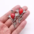 Silver alloy devil wings key pendant with red turquoise gemstone inlay in palm view - Red Network Jasper