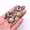 Retro viking dragon pendant in silver finish holding a yellow natural stone bead - 43x43mm / Topaz