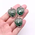 Three green crystal heart pendants with silver tree of life design in hand - Green Aventurine