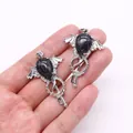 Gothic silver key pendant with black marble stone and angel wings held in hand - Black Line Howlite
