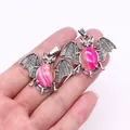 Silver-finished bat pendant with pink striped stone held to show size and detail - Rose Red Banded Agate
