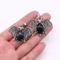 Silver bat pendant with blue sandstone and black agate stones, hand-held for scale - Black Agate