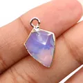 Close-up of light purple faceted gemstone pendant with gold-plated edge held in hand - Opal
