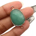Macro detail of oval faceted green gemstone connector with gold plated edges for DIY jewelry - Green Aventurine