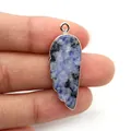 Vue macro détaillée du pendentif en pierre bleue en forme de plume aux bords dorés - Sodalite