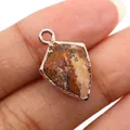 Macro view of a shield-shaped dalmatian stone pendant with gold plating for DIY jewelry - Jasper