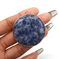 Macro detail of round natural blue stone pendant with rose gold plated metal edging decoration - Blue Spot Stone