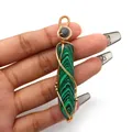 Macro detail of hexagonal malachite pendant with intricate golden wire wrapping - Hexagonal Column Wire Wrap Style / Malachite