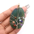 Detail van levensboom hanger met groene agaat en kleurrijke chakra kralen in de hand getoond - 30-60mm / Groene agaat