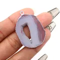 Purple natural agate geode slice pendant with silver plated edges on a person's hand - Light Purple