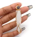 Close-up of handmade gold wire-wrapped hexagonal white crystal pendant held by hand - Hexagonal Column Wire Wrap Style / White Crystal