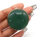 Natural round malachite stone pendant with gold plated bezel held by hand - Green Aventurine