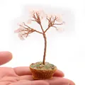 Primer plano de un árbol de cristal rosa hecho a mano sostenido para mostrar su tamaño mini - Cuarzo rosa