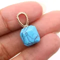 Macro view of a square cut blue turquoise pendant with a gold textured metal bail - Blue Turquoise