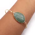 Gold plated open bracelet featuring a large oval green natural stone on wrist - Green Aventurine