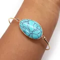 Gold plated open bangle featuring a large oval turquoise stone with black veining - Blue Turquoise