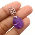Gros plan d'un pendentif améthyste goutte avec fermoir feuille en or rose et diamants - Améthyste