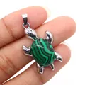 Ciondolo tartaruga d'argento con pietra di malachite verde tenuto in mano - Malachite