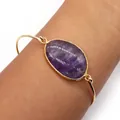 Gold open bangle featuring a large oval purple natural stone and minimalist metal band - Purple Crystal