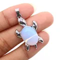 Ciondolo tartaruga argento con opale blu tenuto in mano per mostrare dimensioni e dettagli - Opale