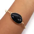 Gold plated open cuff bracelet featuring a large oval black natural stone inlay - Black Agate