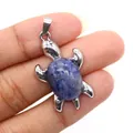 Ciondolo a tartaruga in argento con pietra naturale blu ovale tenuto in mano - Sodalite