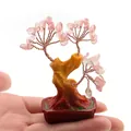 Macro-opname van een kleine roze kristallen geluksboom in een rode pot op hand - Watermeloen Kwarts