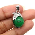 Silver dolphin pendant with green gemstone bead held between fingers for size reference - Dolphin Shape / Malay Jade