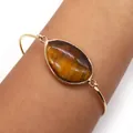Gold plated open bangle featuring an irregular natural brown tiger eye stone - Tiger's Eye