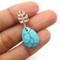 Pendentif goutte en pierre bleue avec fermoir feuille dorée et zircons blancs - Turquoise Bleue