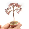 Miniature handmade life tree with copper wire and pink crystal stones held in hand - Strawberry Quartz