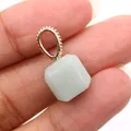 Light green geometric faceted stone pendant with decorative gold bail held by hand - Green Aventurine