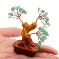 Miniature green crystal money tree figurine in a red square pot held on a fingertip - Green Aventurine