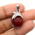 Hand holding silver dolphin pendant with red round natural stone for jewelry making - Dolphin Shape / Red Agate