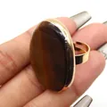 Anillo dorado ajustable con una gran piedra ojo de tigre ovalada y reflejos - Abierto Ajustable / Ojo de tigre