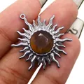 Dettaglio del ciondolo a girasole in lega con gemma ambra e finitura argento antico - Occhio di tigre