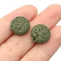 Dettaglio macro di due perle di pietra lavica verde scuro con trama naturale sulla punta del dito - 12 mm (spessore 6 mm) / N. 8 (Verde scuro)