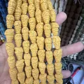 Macro shot of hand holding bright yellow cone-shaped porous lava stone beads for jewelry DIY - Yellow (No.13)