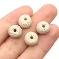 Beige volcanic lava stone beads for DIY diffuser jewelry making shown on fingers - No. 2 (7x10mm) / Beige