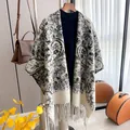 Retro paisley pattern cashmere shawl with tassels over a black turtleneck sweater - White