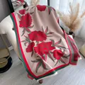 Elegant floral cashmere-feel scarf with tassels draped on a white chair in a cozy room - Red