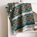 Detail of knit scarf with elephant plaid pattern and decorative long tassels - 180x65cm / Green